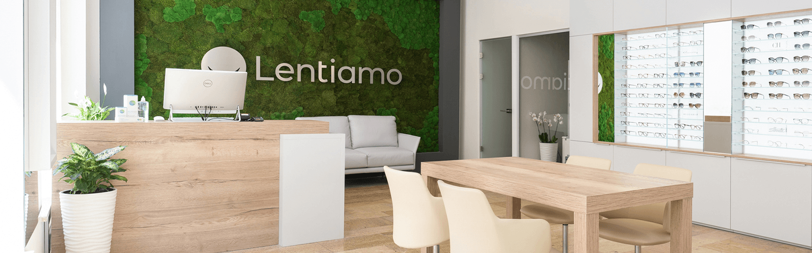 moderni optikos parduotuvė su akinių ekspozicija ir siena su žaliomis samanomis